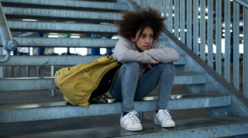 Sad girl sitting on stairs.